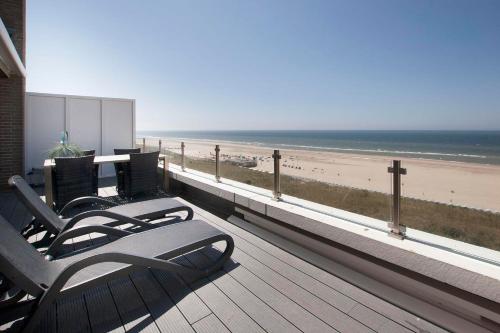 a balcony with a view of the beach at Apartments with unique sea view in Egmond aan Zee