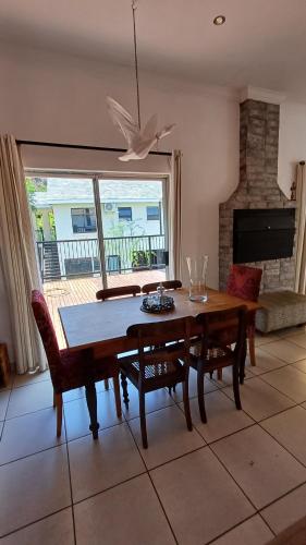 a dining room with a table and chairs and a window at Harties Boathouse in Hartbeespoort