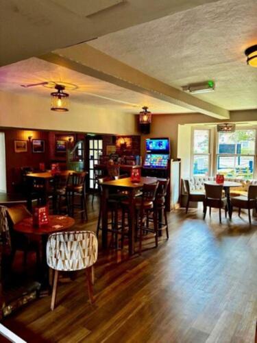 a bar with wooden floors and tables and chairs at The Poacher Portishead in Portishead