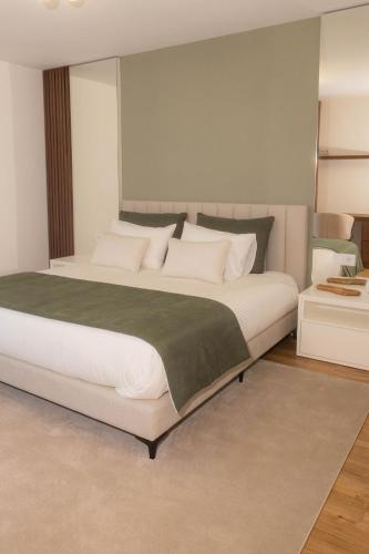 a bedroom with a large bed with white pillows at BLUE residence apartment in Póvoa de Varzim