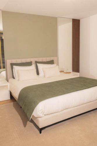 a bedroom with a large bed with white pillows at BLUE residence apartment in Póvoa de Varzim