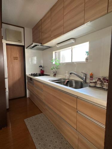 a kitchen with wooden cabinets and a sink at 新宿駅2分 jr新大久保駅徒歩8分 歌舞伎町徒歩10分 in Tokyo