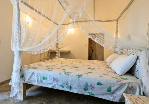 a bedroom with a bed with a mosquito net at South Roots in Unawatuna