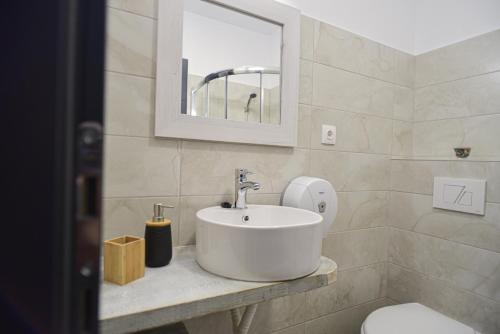 a bathroom with a sink and a toilet and a mirror at Süni Vendégház in Căpîlniţa