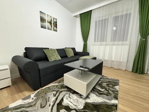 a living room with a couch and a table at Cozy green apartament in Mediaş
