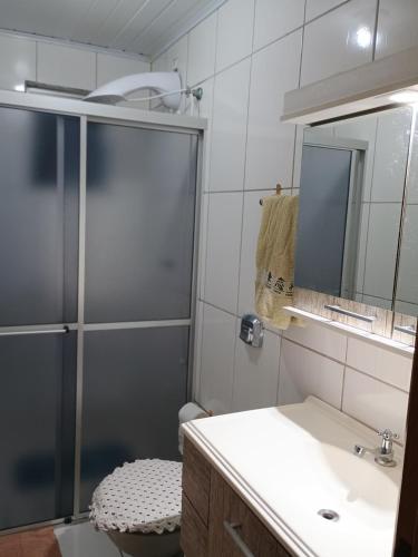 a bathroom with a shower and a sink and a toilet at Refúgio na Serra Gaúcha in Nova Petrópolis