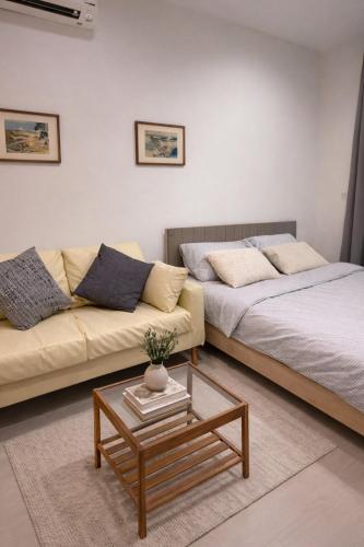 a living room with a couch and a coffee table at Cozy Japandi Stay on Sukhumvit in Bangkok