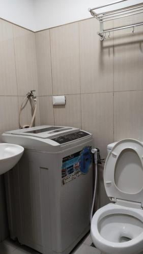 a small bathroom with a toilet and a sink at Nygel Staycation at Shell Residences in Sampong