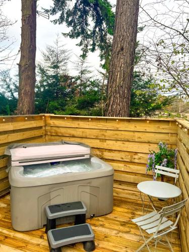 a hot tub on a deck with a table and chairs at Boann 5 - Hot Tub-Hunting Tower Lodges-Luxury-Families-Romantic in Perth