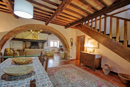 cocina y sala de estar con mesa y escalera en Holiday Home Casale Giulio by PosarelliVillas, en Cetona
