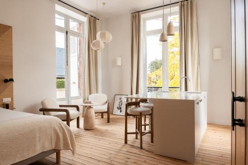 a bedroom with a bed and a kitchen with a table at Villa Chantereine in Cabourg