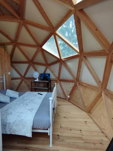 a bedroom with a bed in a wooden room at L'Orée des 4 chemins in Fontenoy