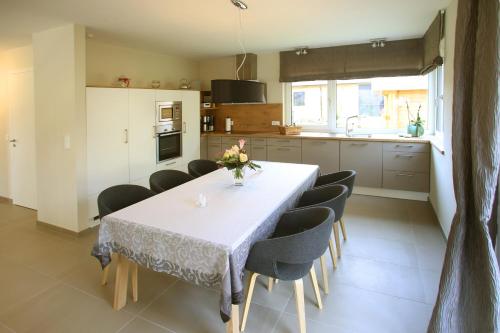 a kitchen with a white table and chairs and a kitchen with at "Strandhus Finka" in Dierhagen