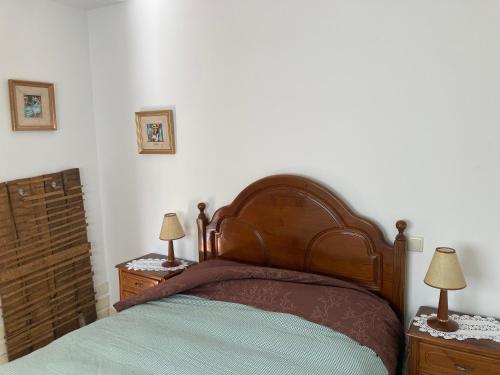 a bedroom with a wooden bed and two night stands at Casa Nova in Apúlia