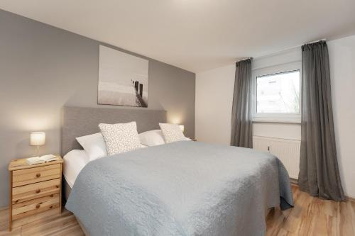 a bedroom with a large bed and a window at Haus Strandgeflüster Sandbank in Grömitz