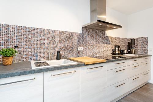 a kitchen with white cabinets and a sink at Ostseeschwimmerin in Schönberg