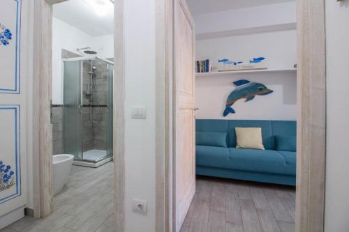 a living room with a blue couch and a shower at GuestHost - Gabbiano Lovely Flat with Veranda in Palau