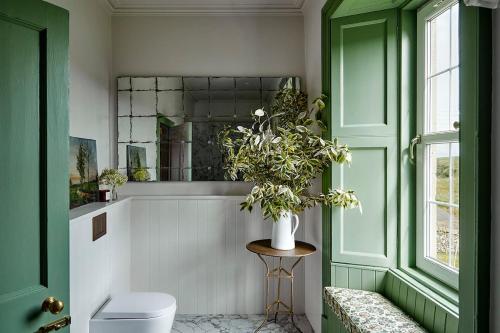 a bathroom with a toilet and a vase of flowers at Banchory Farm in Fife