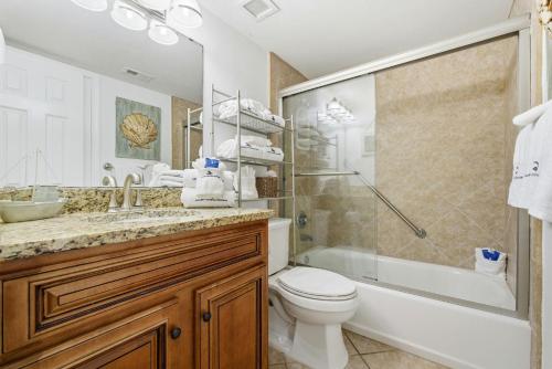 a bathroom with a toilet and a shower and a sink at SeaSpray Riverside 712 in Perdido Key