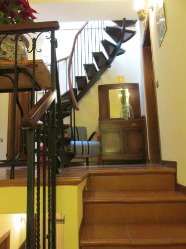 a stairway with a wooden spiral staircase with a mirror at Hotel Pallotta in Assisi