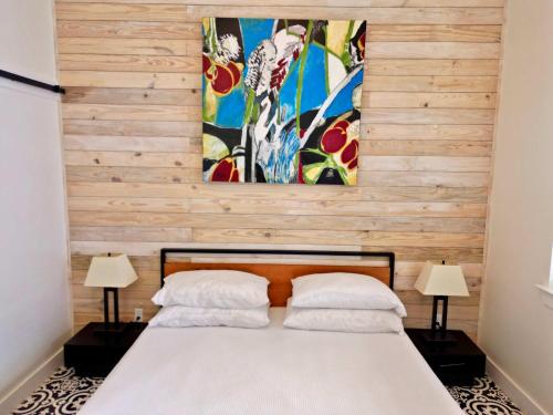 a bedroom with a bed with two lamps and a painting at Lodge 2 on the Mason TX square in Mason