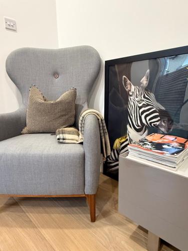 a living room with a chair and a tv at Modern apartment, free parking within walking distance of Churchill Hospital in Oxford