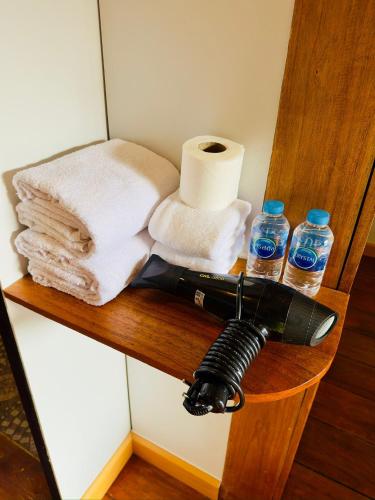 a flashlight on a shelf with toilet paper and water bottles at Phayam Paradise Resort in Ko Phayam