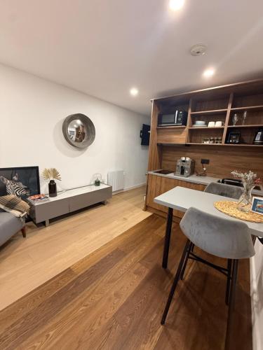 a living room with a table and a couch at Modern apartment, free parking within walking distance of Churchill Hospital in Oxford