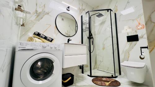 ein Badezimmer mit Waschmaschine und Dusche in der Unterkunft Bydgoszcz GOLD 7 z sypialnią in Bydgoszcz