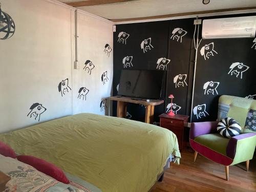 a bedroom with a bed and a tv and a chair at Departamento Terraza in Molina