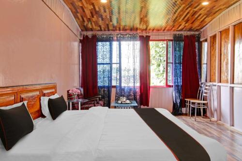 a bedroom with a large bed with red curtains at Hotel Lake Side in Srinagar
