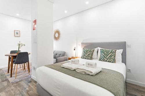 a bedroom with a large white bed with towels on it at GuestReady - Douro D'or Apartments in Vila Nova de Gaia