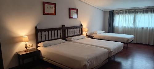 a hotel room with two beds and a window at Hotel Conde Rodrigo II by eme hoteles in Ciudad-Rodrigo