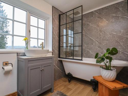 a bathroom with a tub and a sink and a mirror at 4 Lilac Cottages in Whitby