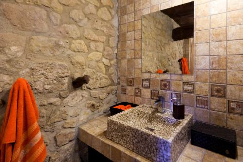 a stone bathroom with a sink and a mirror at Cal Campllarg in Caserras