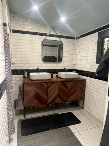 a bathroom with two sinks and a mirror at La Noirie in Saint-Étienne