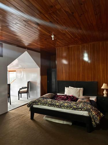 a bedroom with a bed and a table and a chair at Kehkashan in Shongran