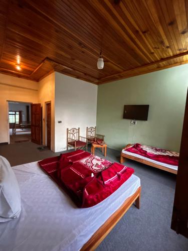 a bedroom with two beds and a television in it at Kehkashan in Shongran