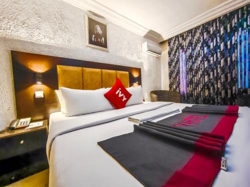 a hotel room with a large bed with red pillows at Aotel Hotels & Suites - Ojota in Lagos