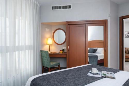 a hotel room with a bed and a mirror at חדר על הים בבת ים in Bat Yam