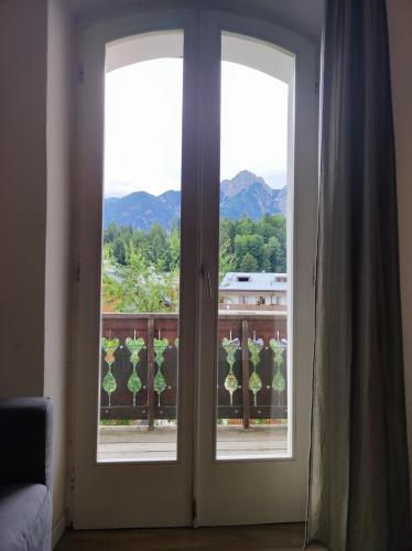 two doors to a balcony with a view of the mountains at La Strada di Tiziano in Pieve di Cadore