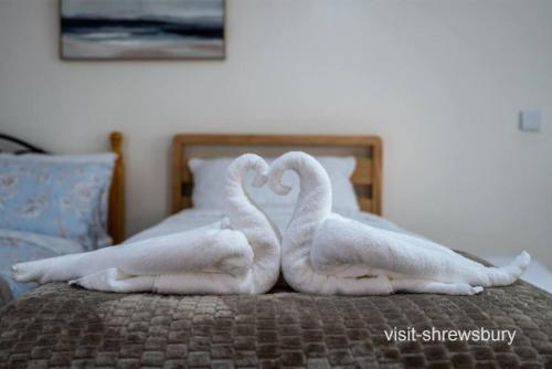 two towelsrendered to look like swans on a bed at Personal En-suite in Shrewsbury