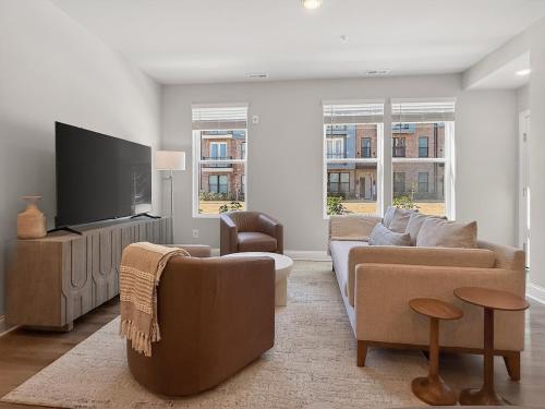 a living room with a couch and a flat screen tv at Luxe King Bed, Balcony, Garage in Downtown Raleigh in Raleigh