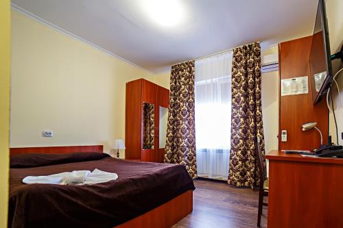 a bedroom with a bed and a desk and a window at New Tengiz Camp in Tengiz