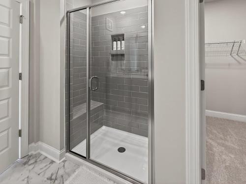 a shower with a glass door in a bathroom at Luxe King Bed, Balcony, Garage in Downtown Raleigh in Raleigh