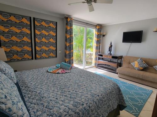 a bedroom with a bed and a living room at 108 Sapphire Beach Condos Barbados in Christ Church