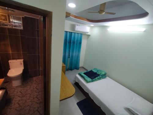 a small bathroom with a bed and a toilet at MD HoTEL in Iswardi