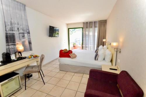 a hotel room with a bed and a desk and a couch at Sure Hotel by Best Western Gemenos en Provence in Gémenos