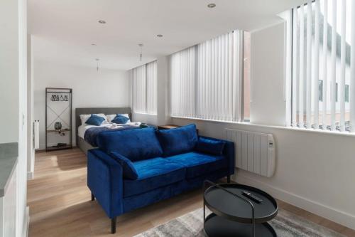 a living room with a blue couch and a bed at Stay Zeni, Alexandra Rise Manchester Sleek Studio in Manchester