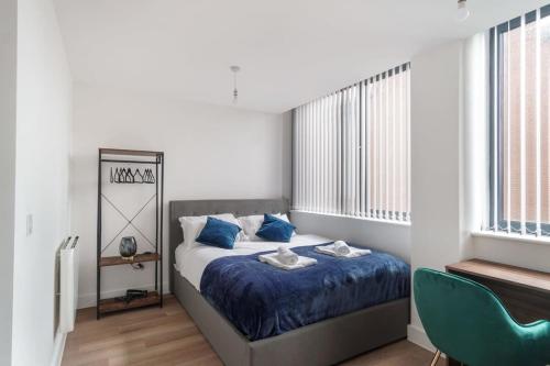 a bedroom with a bed with blue sheets and blue pillows at Stay Zeni, Alexandra Rise Manchester Sleek Studio in Manchester
